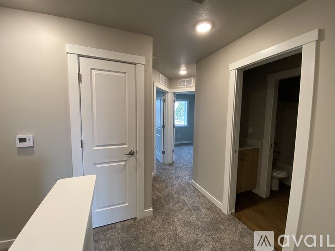 A room with a white door and a window with a view of a building outside.