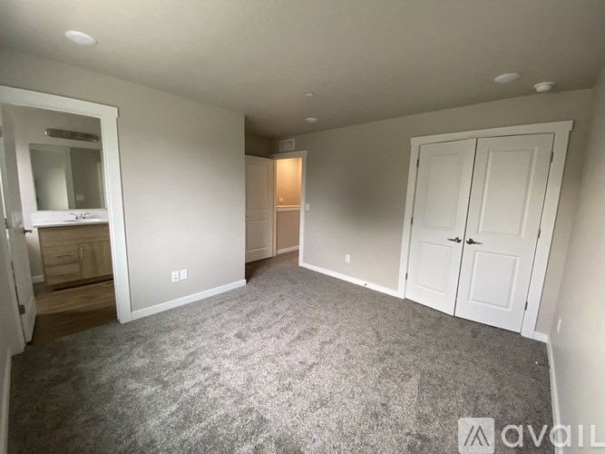 A room with a grey carpet and white walls.