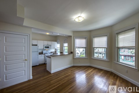 A kitchen with a white door and a window with a view of houses.