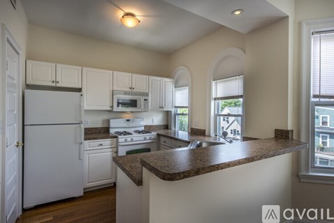 A kitchen with white appliances and a brown countertop.