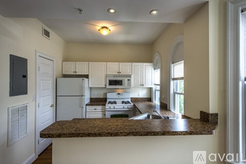 A kitchen with white appliances and a granite countertop.
