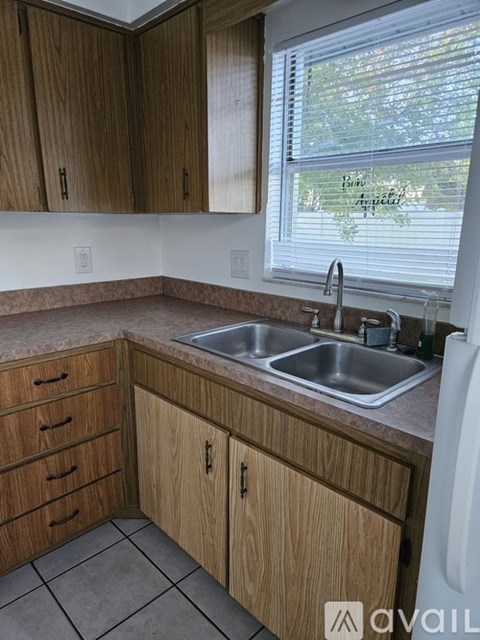A kitchen with wooden cabinets and a white fridge.