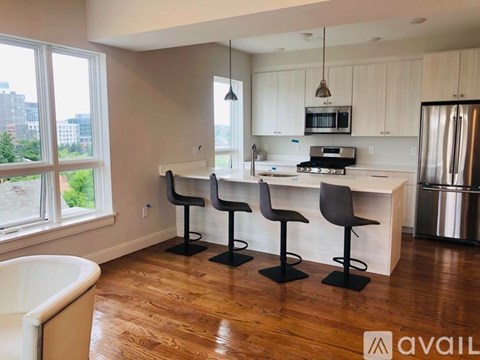 A kitchen with white cabinets and a wooden floor.