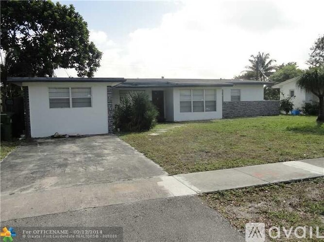 A white house with a grey roof and a concrete driveway.