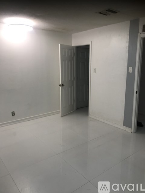 A room with a white door and a white wall.