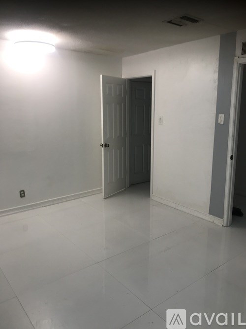 A room with a white door and a white wall.