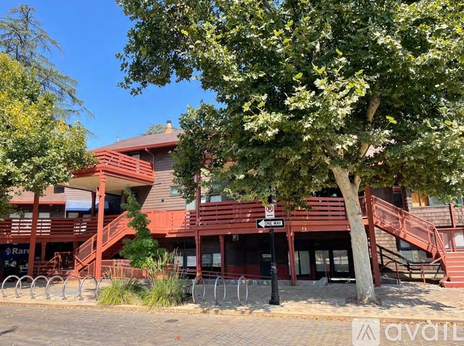 A tree in front of a red building with a sign that says "Rare".