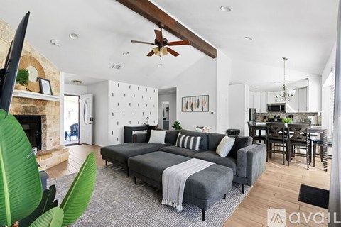 A living room with a grey couch and a fireplace.