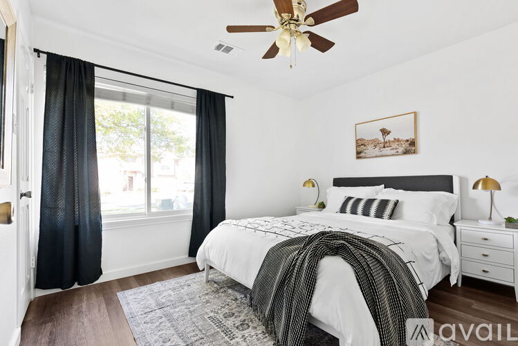 A bedroom with a large bed and a ceiling fan.