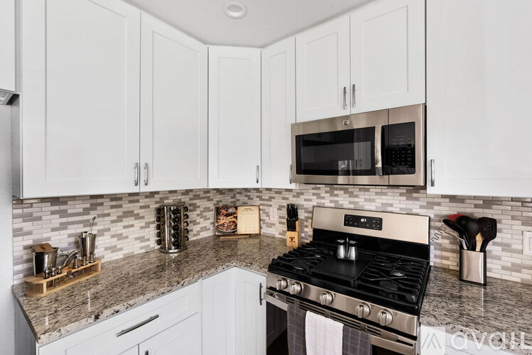 A kitchen with white cabinets and a black stove top.
