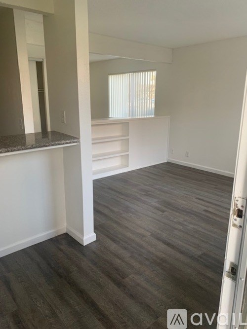 A room with a white wall and a grey floor.