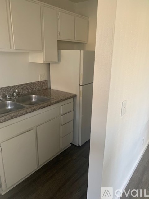 A kitchen with white cabinets and a granite countertop.