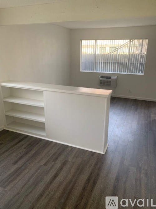A white shelf unit in a room with a window.
