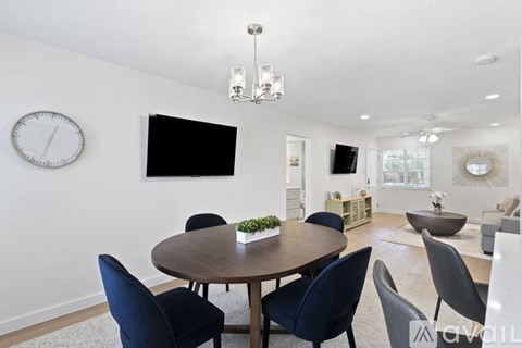 A modern dining room with a round table and chairs.