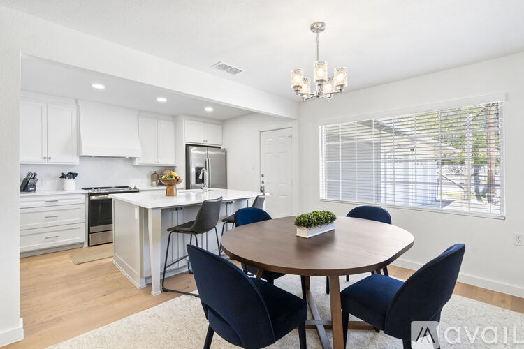 A modern kitchen with a dining table set for four.