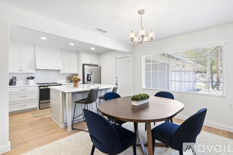 A modern kitchen with a dining table set for four.