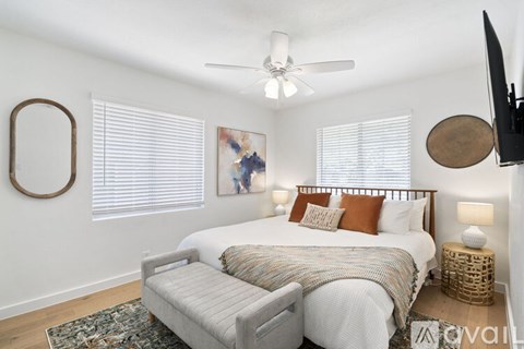 A bedroom with a large bed and a ceiling fan.