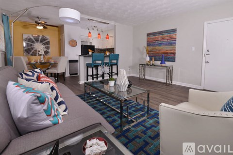 A living room with a grey couch and a glass coffee table.