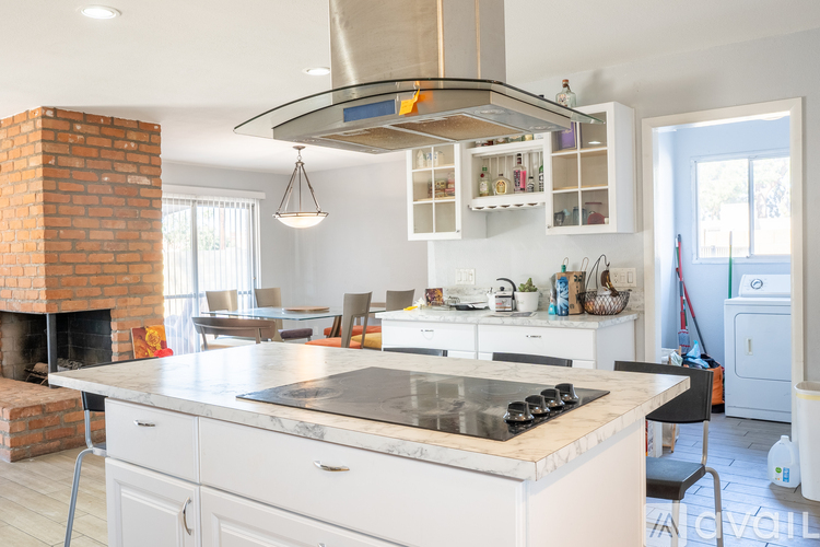 A modern kitchen with a brick fireplace and a large island.