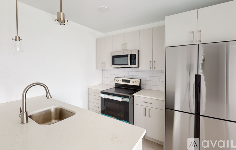 A kitchen with a sink, stove, and refrigerator.
