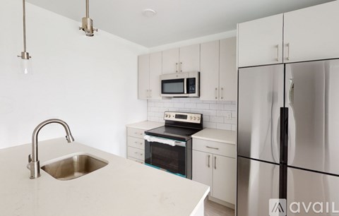 A kitchen with a sink, stove, and refrigerator.