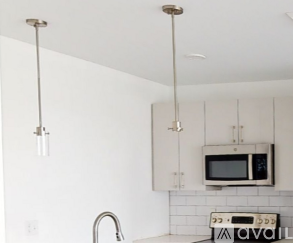A kitchen with white cabinets and a microwave.
