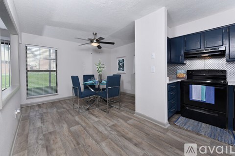 A kitchen with a black oven and blue chairs.