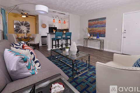 A living room with a grey couch and a glass coffee table.