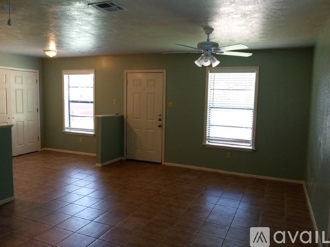 A room with a ceiling fan and two windows.