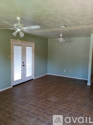 A room with tile flooring and two ceiling fans.