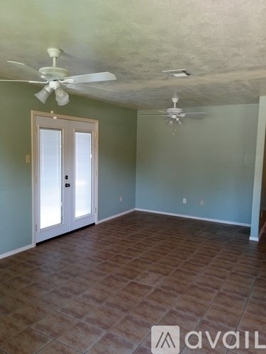 A room with tile flooring and two ceiling fans.