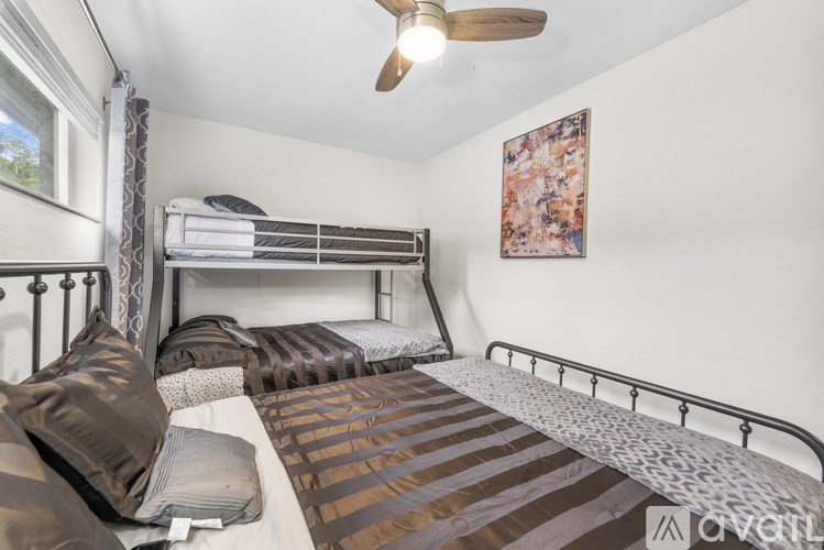A bedroom with a bunk bed and a ceiling fan.