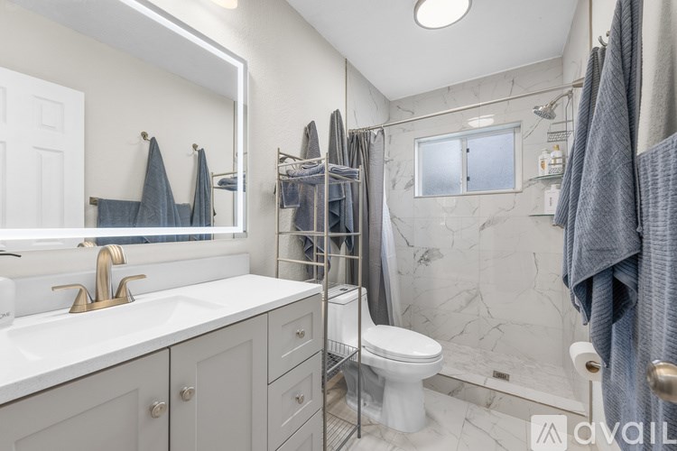 A bathroom with a white sink and a white toilet.