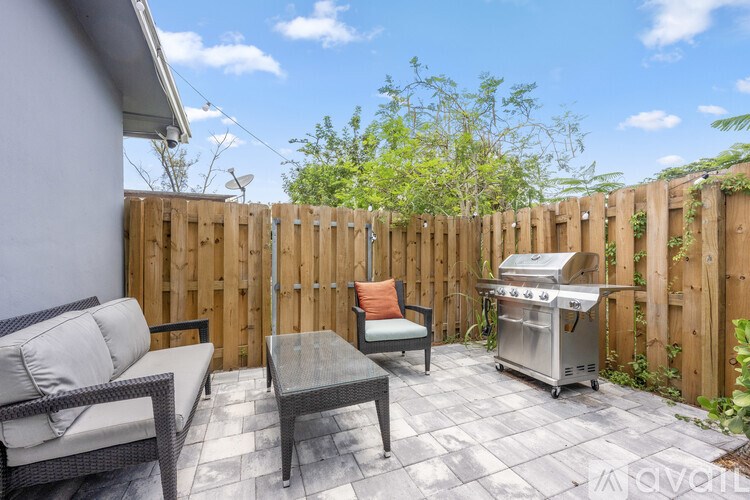 A bedroom with a bed, a couch, and a painting on the wall.