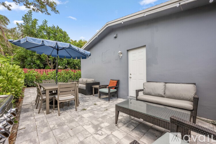 A room with a bed, a chair, and a painting on the wall.