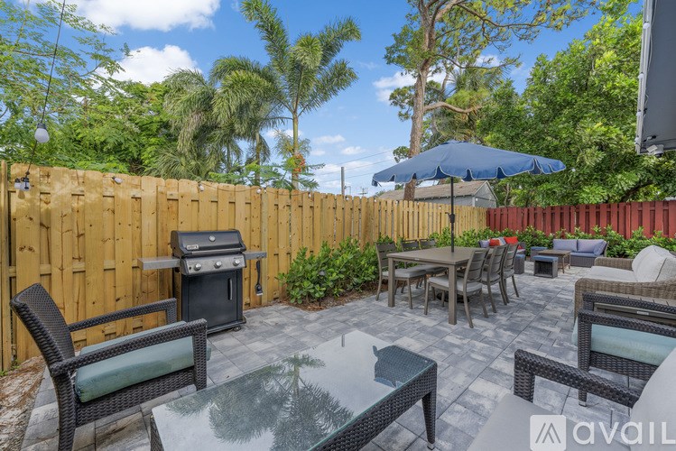 A patio with a glass table surrounded by a wooden fence.