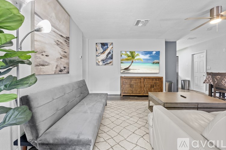 A living room with a wooden coffee table and a large painting on the wall.