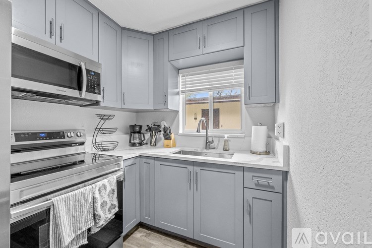 A kitchen with a stainless steel refrigerator, microwave, and oven.