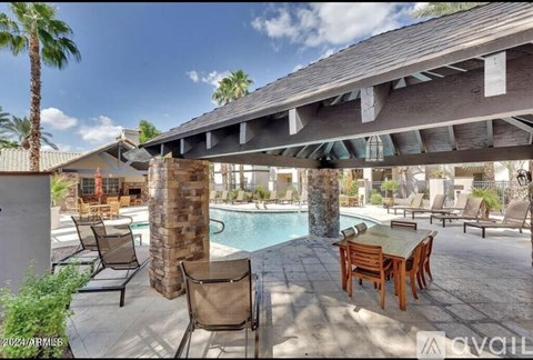 A poolside patio with chairs and a table.