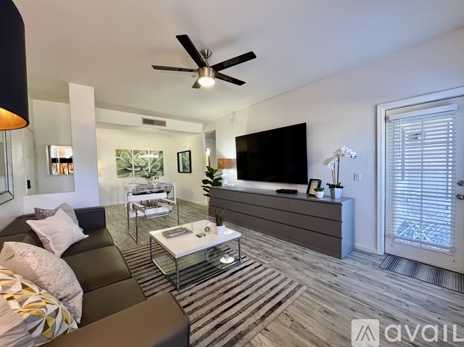 A living room with a dark sofa and a white coffee table.
