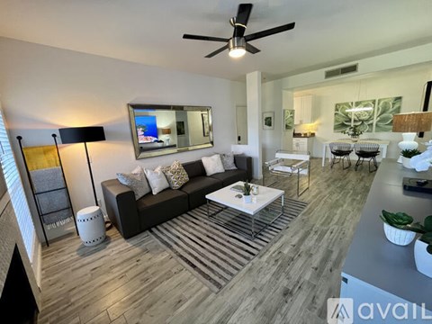 A living room with a dark sofa and a white coffee table.