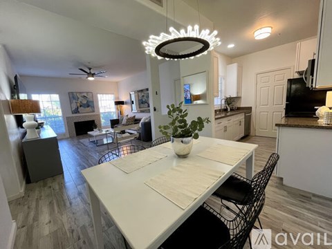 A modern dining room with a white table and chairs.