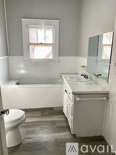 A bathroom with a white tub, sink, and toilet.
