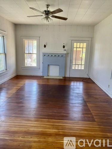 A room with a fireplace and wood flooring.