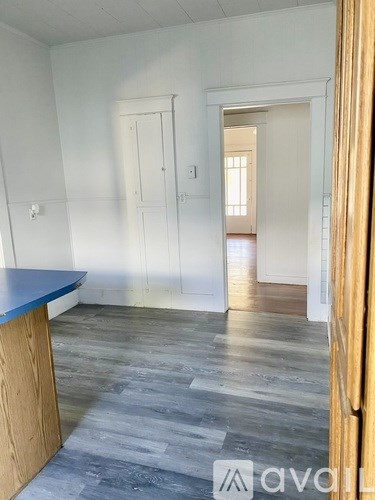 A room with a blue counter and wooden floors.