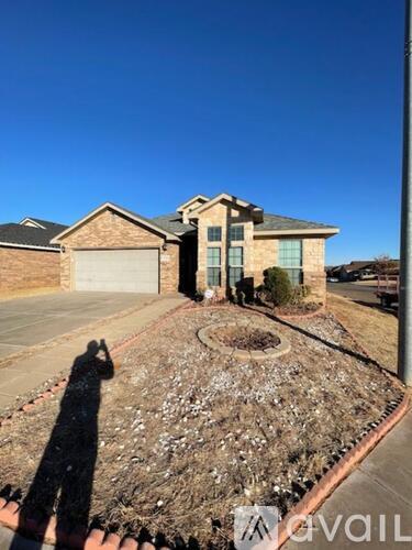 A house with a driveway and a garden in front.