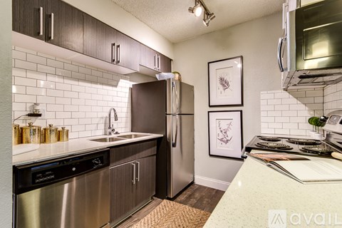 A kitchen with a white counter top and stainless steel appliances.