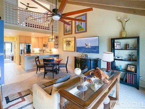 A living room with a glass coffee table and a ceiling fan.