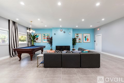 A living room with a pool table and a couch.