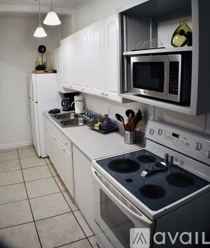 A kitchen with white cabinets and a black stove top.
